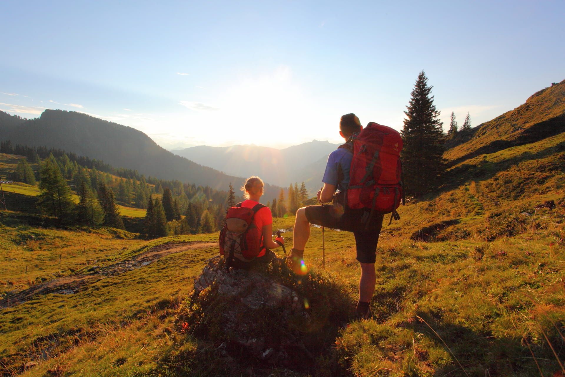 Ein Paar beim Betrachten des Sonnenuntergangs am Loosbuehel in Großarl 